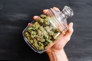 Person holding jar of cannabis 
