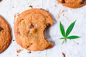 weed cookie is shown with a bite taken out of it and a cannabis leaf beside it