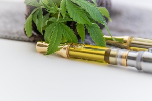 cannabis cartridge with a cannabis plant on a table