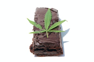 Cannabis Edibles on white background with a cannabis flower laying on top