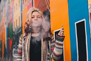 blonde woman smoking a cannabis vape pen