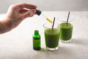 cbd oil dropper bottle and cannabis infused green health drink