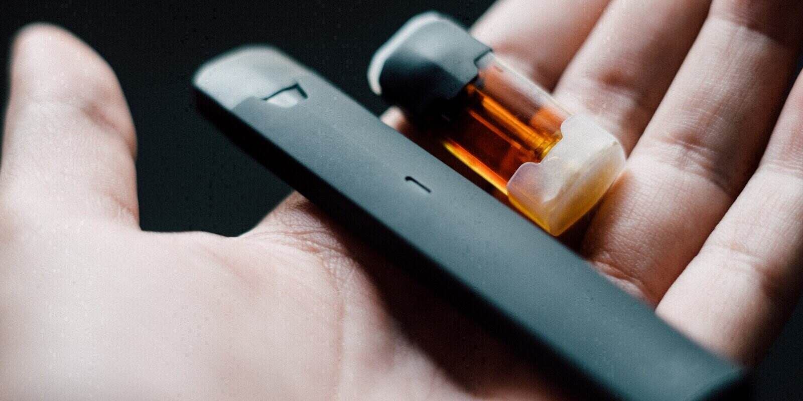 disposable vape pen with refill pod on hand