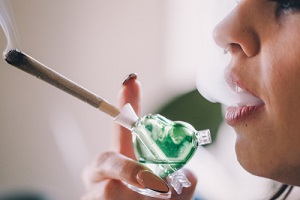 girl smoking weed out of a glass joint pipe bubbler