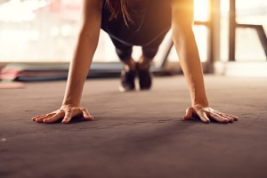 woman hand doing push ups exercise in a gym