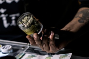 budtender showing off a jar of cured cannabis flowers