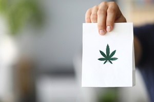 Courier,Hand,Passing,Package,With,Marijuana,To,Client,Close-up