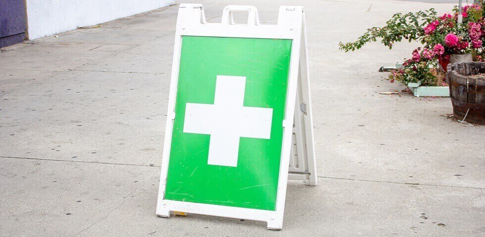 general white and green cross symbol indicating a nearby marijuana dispensary