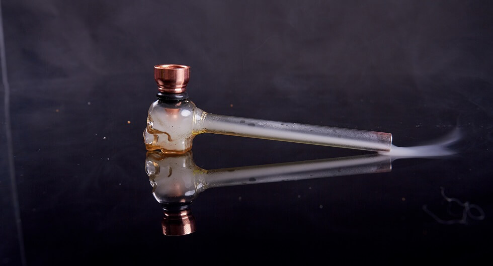 cannabis glass pipe on reflective mirror surface