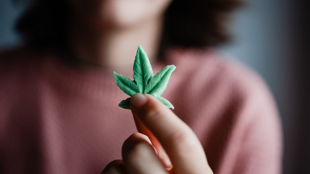 Boston woman holding cannabis candy leaf for anxiety treatment