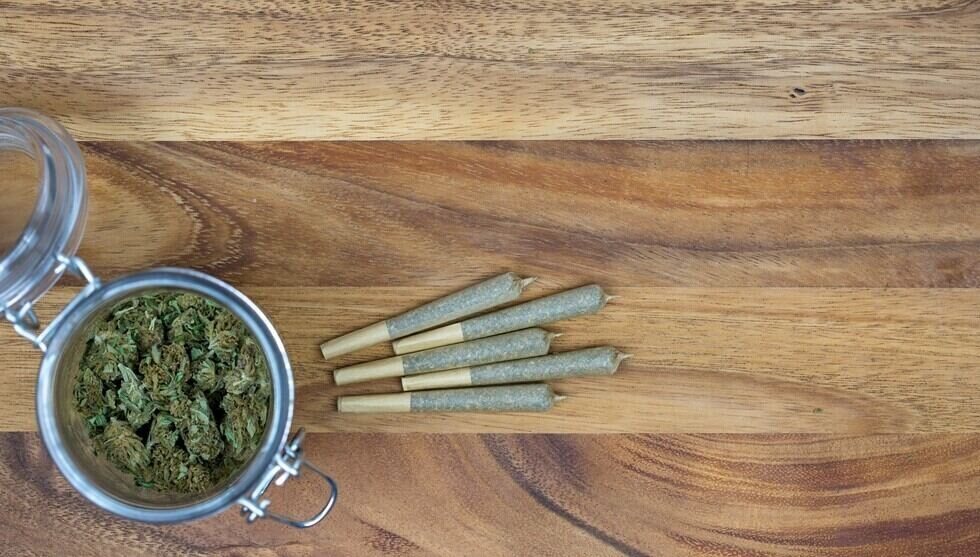 weed in jar with cone joints on wood surface