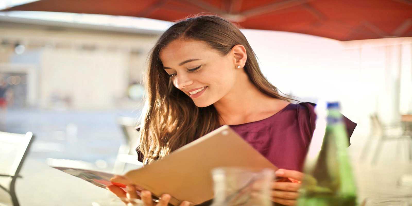 Smiling Girl Reading Boston Dispensary Cannabis Menu