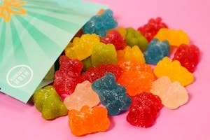 Colorful CBD Gummies Spreaded on Pink Surface